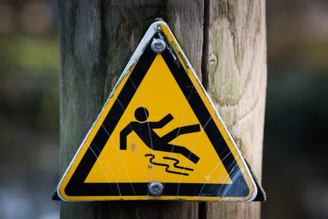 A slip and fall accident warning sign on a post