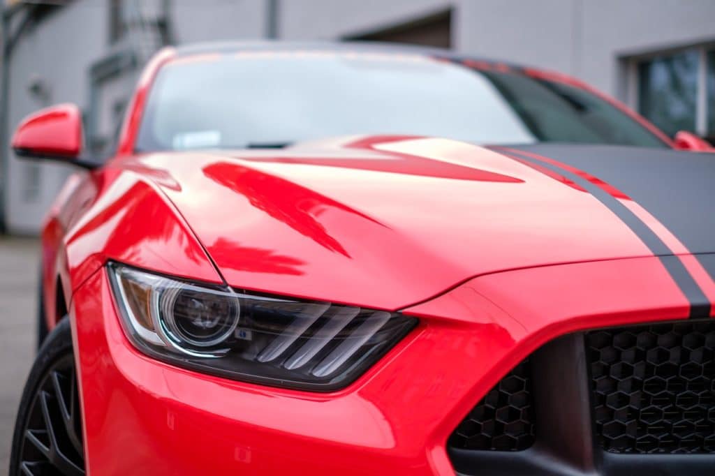 Closeup of the front side of a red sports car parked
